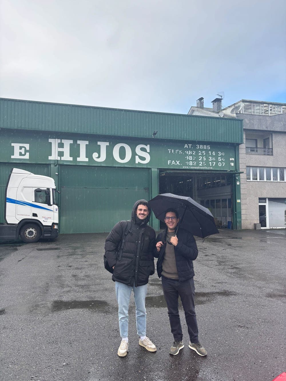 Two Traza team members outside a client's warehouse in the rain.