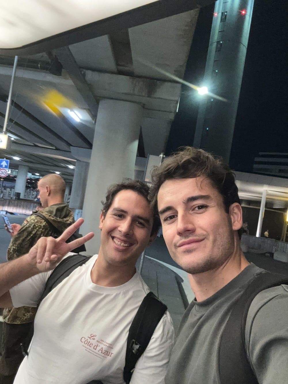 Two Traza team members taking a selfie at an airport at night.
