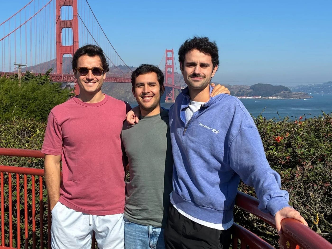 Three Traza team members in front of the Golden Gate Bridge.